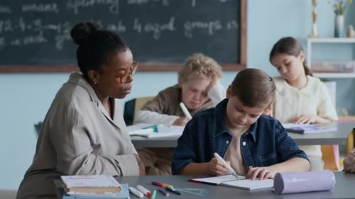 Teacher Helping Student with Schoolwork in Classroom