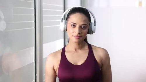 Athletic woman in workout clothing smiles indoors