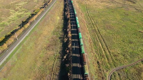 Freight Train Moving Through Rural Landscape Aerial