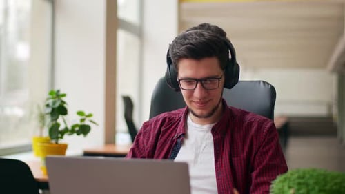 Young Adult Working at Laptop in Office Setting