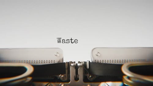Old mechanical typewriter typing Waste Overload in a close-up view.