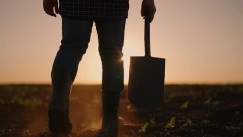 Bodenbearbeitung und Bepflanzung im Frühling Silhouette eines Landwirts im Feld Erfolgreicher Betrieb