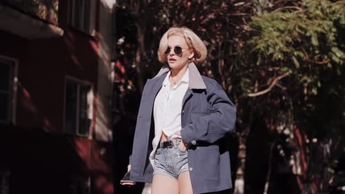 Attractive senior woman walking down the street with flying hair. Happy relaxed lady walking.