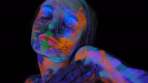 A Magical Space Girl with UV Drawings on Her Face and Body in the Dark