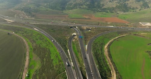 Day traffic on a countryside bridge surrounded by lush green landscape