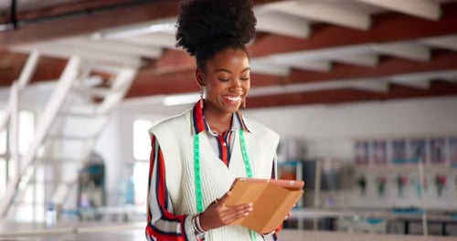 Smiling Fashion Designer Uses Tablet in Studio