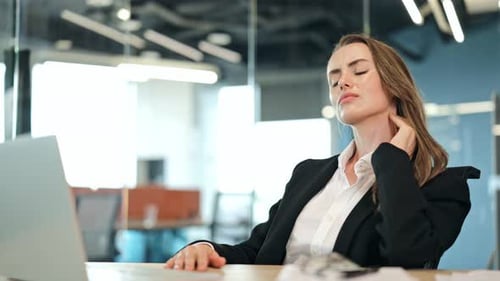 Tired Businesswoman Relieves Neck Pain In Office