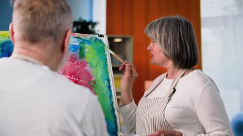 Senior Couple Painting Canvas Together Indoors