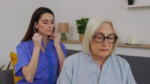 Caring Doctor Examines Senior Woman at Home
