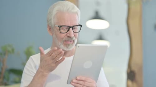 Senior Man Uses Tablet for Video Call
