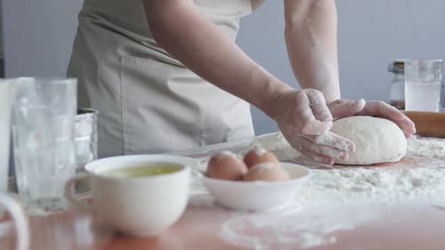 Experienced professional cook, baker forms dough and starts to cook bread using traditional methods.