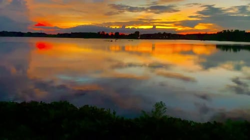 The beautiful sunset over the calm waters of the lake makes for a perfect view