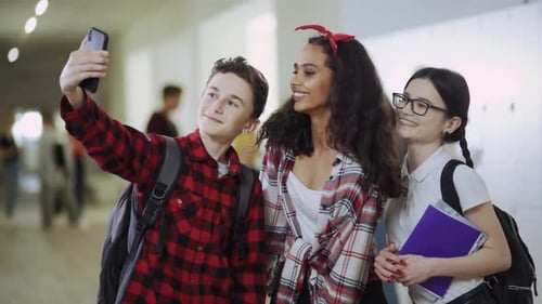 A Group of Teenagers is Taking a Fun and Candid Selfie Together in the School Hallway