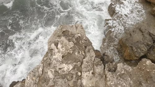 Ondas batem na costa rochosa do mar ou oceano, vista superior