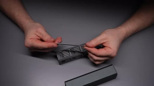 Nahaufnahme von oben auf männliche Hände eines Technikers, der einen Schraubenzieher-Bit aus dem Präzisions-Bit-Set auswählt