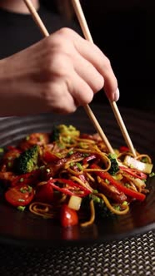 Close Up of Person Eating Vegetable Noodles