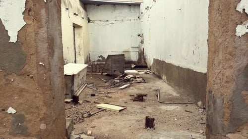 Decaying walls framing debris-filled room in Barbate, Spain