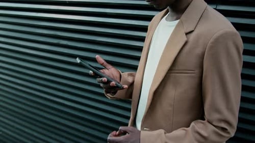 Stylish Man Using Smartphone Outdoors in Urban Setting
