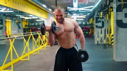 Muscular Man Bicep Curls in a Gym