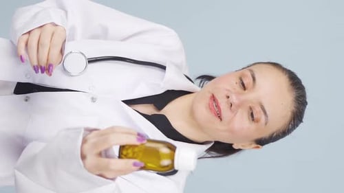 Smiling Woman Doctor Holding Bottle of Pills
