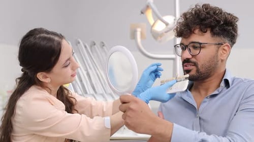 Dentist Matching Teeth Color with Patient in Office