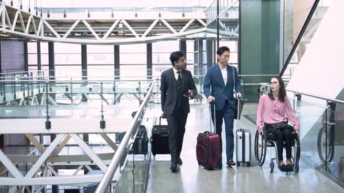 Business People Pulling Luggage in Modern Airport