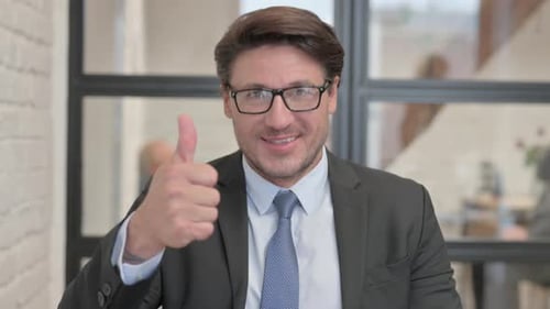 Professional Man Gives Thumbs Up in Office