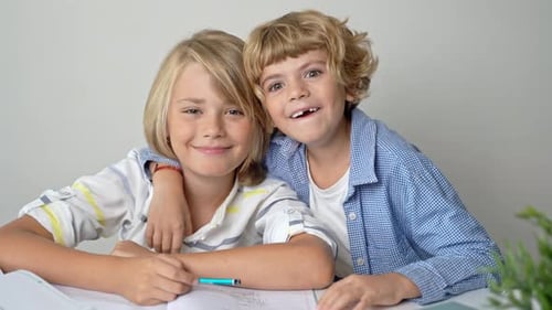 Irmãos do Ensino Fundamental Primário, Meninos e Meninas Estudando na Mesa, Escrevendo em Livro e Tablet