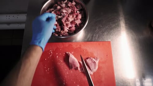 Chopping Raw Meat on Cutting Board in Kitchen