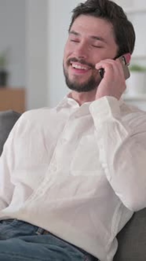 Man Relaxing on Couch and Answering Phone