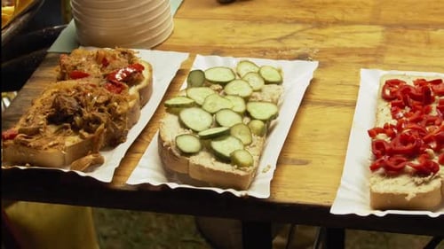 Drei Sandwiches auf riesigen Brotscheiben liegen auf dem Tisch. Mit Pastete, Schmalz, Gurke und Paprika.
T