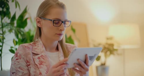 Woman With Glasses Using Tablet Device Indoors