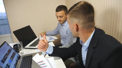 Group of Young Business People Sitting at Table in Modern Office and Working on New Project