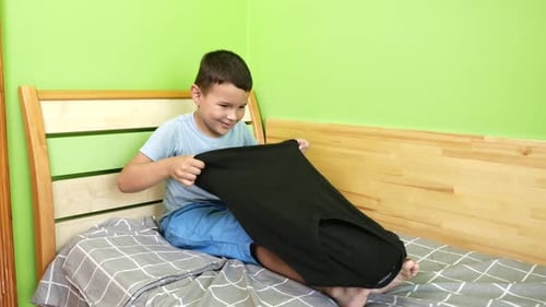 72. The boy carefully folds his clothes. Homework. Washing, ironing and folding clothes.