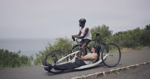 Men Cycle Near Ocean on Overcast Day