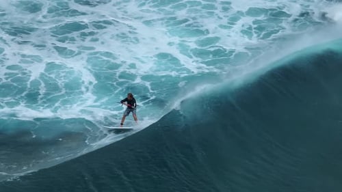 An Athlete on a Wave Board Rides the Big Ocean Waves of a Living Reef in the Indian Ocean
