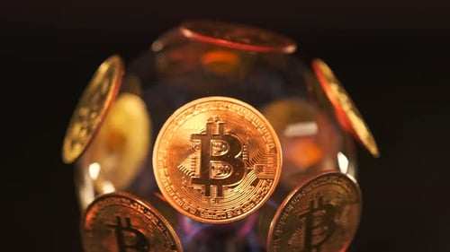 La
boule de pièces Bitcoin BTC en or clair tourne sur fond noir, gros plan. Le monde en monnaie cryptée