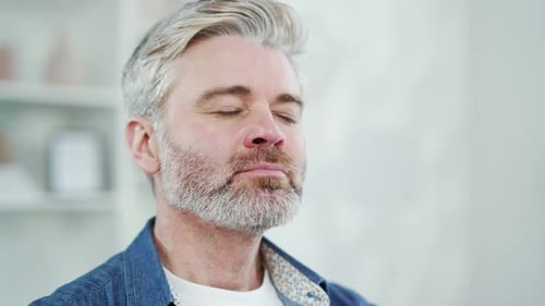 Close up. Portrait of a mature gray haired bearded man resting with closed eyes at home. Tired male