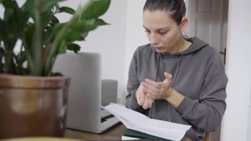 Woman Counts Coins at Desk
