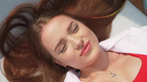 Brunette girl sunbathing in a chaise lounge close up.