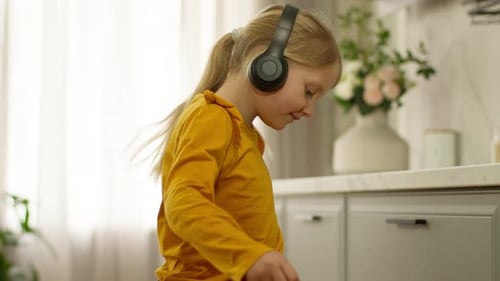 Child Dances at Home with Wireless Headphones