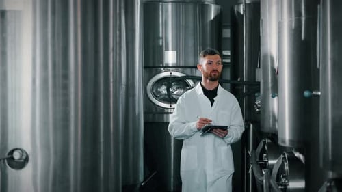 Un technologue se promène dans le département de fermentation d'une brasserie moderne
