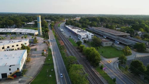 Forwards fly above suburb at golden hour. Transport terminal, logistic or commercial halls and traff