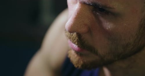 Close up of the face of a tired and sweaty man who has just finished a workout and breathes heavil