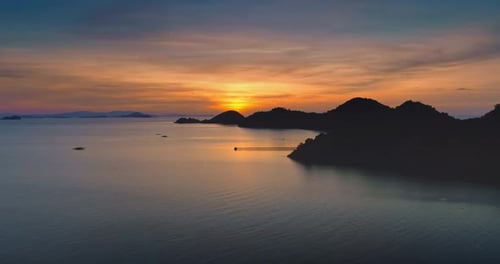 Sunset Illuminating Calm Sea and Volcanic Silhouette in Flores Indonesia