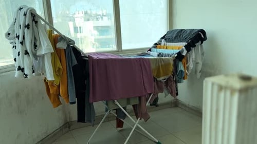 Indoor Clothes Drying Rack Near Window with Urban Residential View