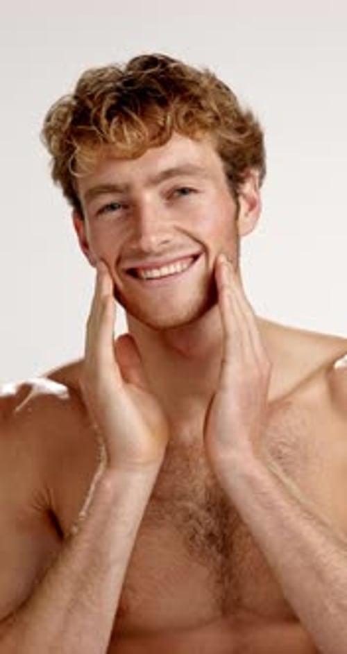 Face, skincare and man in studio, smile and facial hair with dermatology on white background