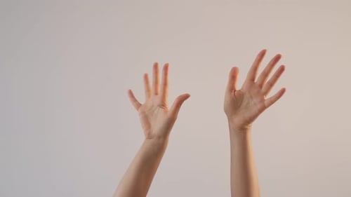 Die Hände der Frau winken, grüßen auf Wiedersehen, machen Handgesten und klatschen in die Hände auf weißem Grund