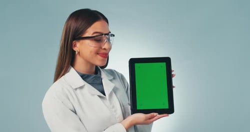 Femme scientifique, tablette et écran vert en studio avec sourire, visage et critique l'application médicale de Blue