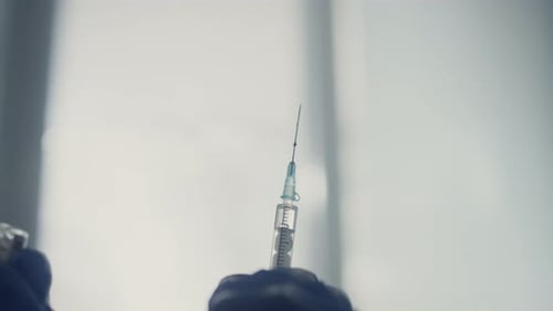 Ärztliche Krankenschwester bereitet in einer modernen Klinik eine antivirale Covid-19-Impfstoffdosisinjektion vor